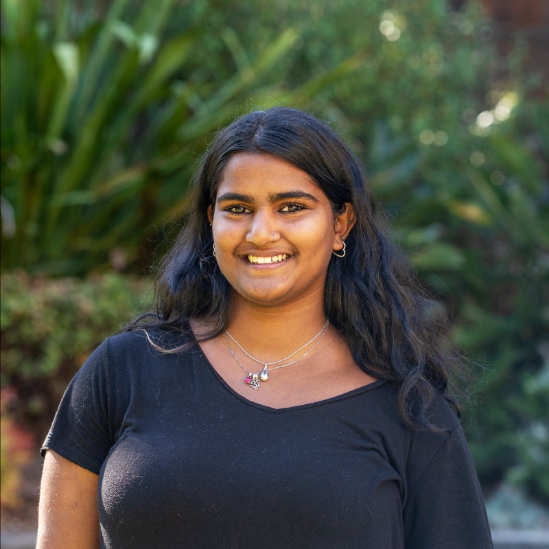 Person smiling at camera standing in garden