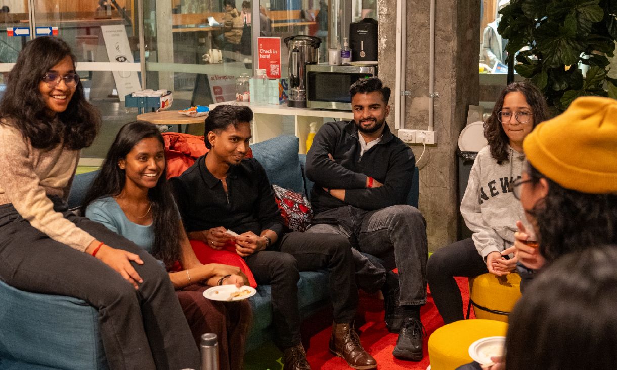 Group of six people sitting in a circle talking