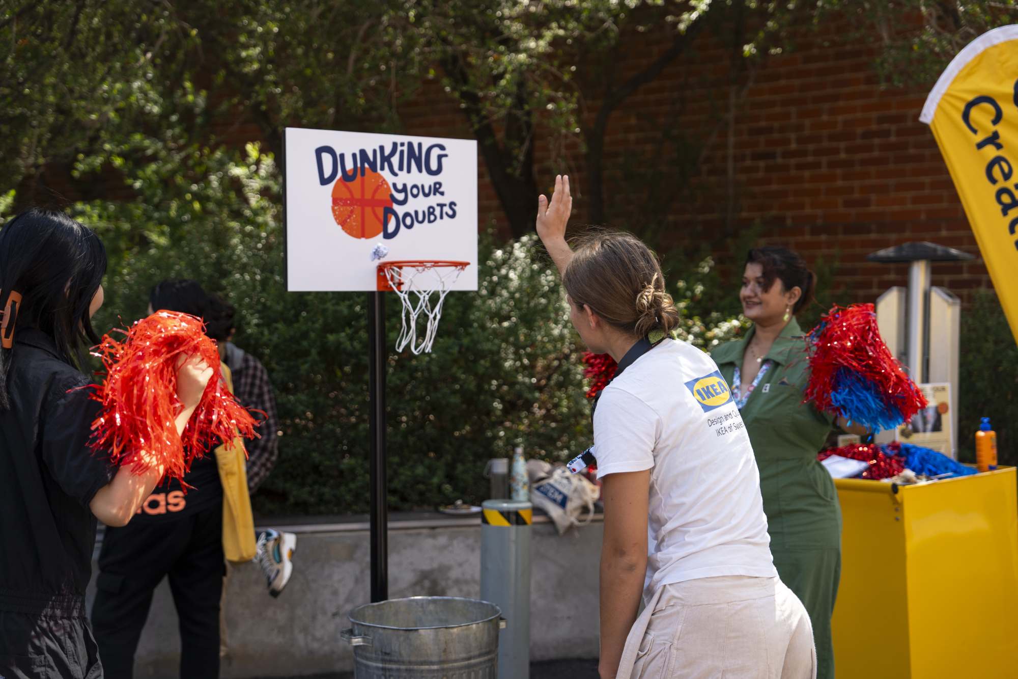 RMIT students throw paper with their worries and doubts into a basketball hoop as apart of the Dunking Your Doubts artwork by Joshua Sullivan 