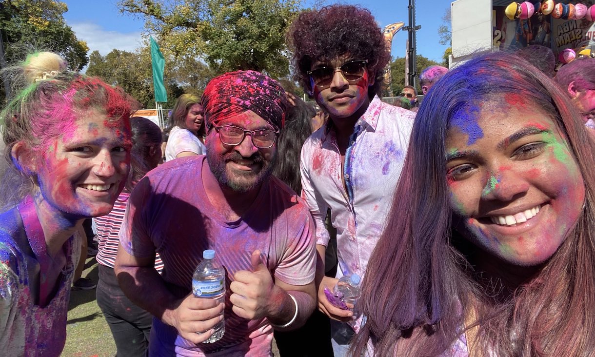 Students at Holi Festival covered in coloured chalk.
