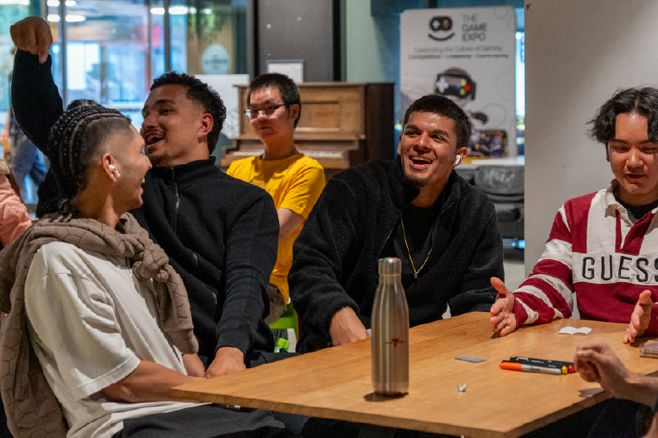 Students sitting around a table having a chat.