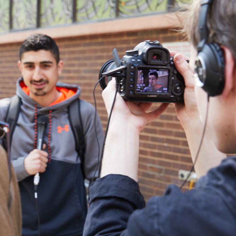 A student films another with a microphone at the City Campus.