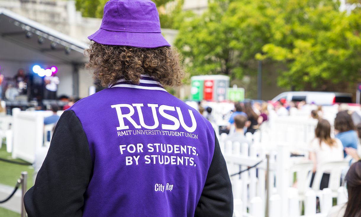 Student wearing purple RUSU jacket.