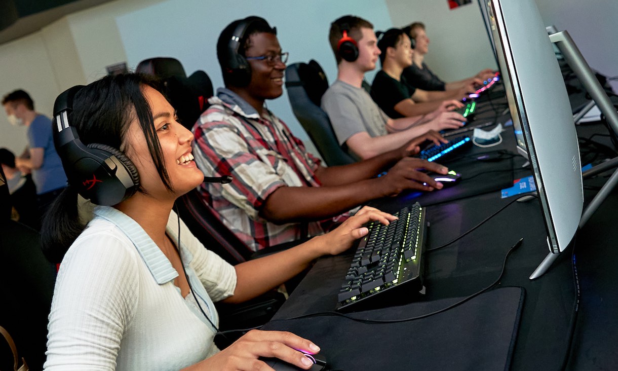 Student smiles as she plays a game on a computer.