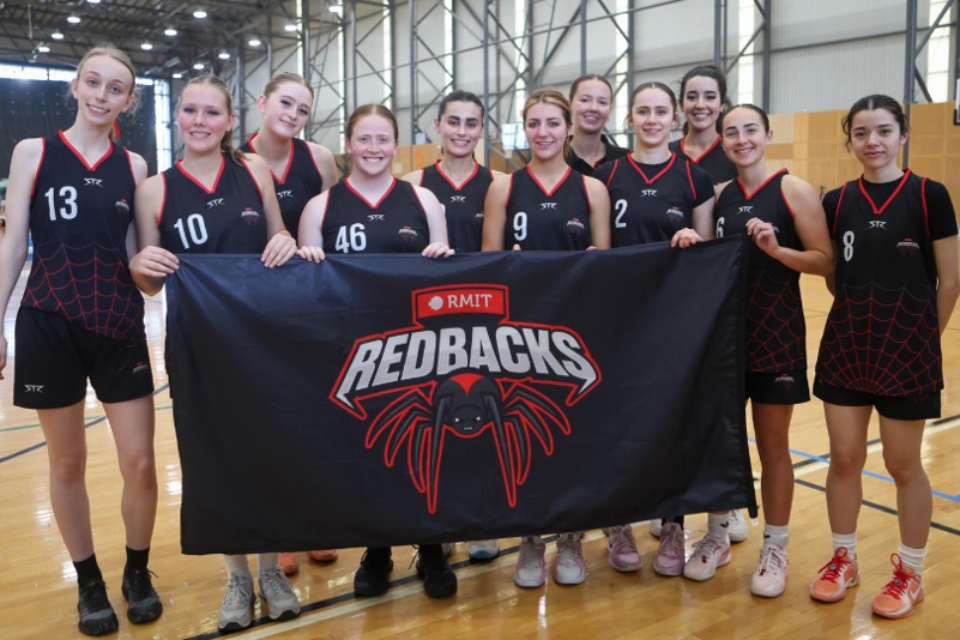 Redbacks mascot with a team on a green field