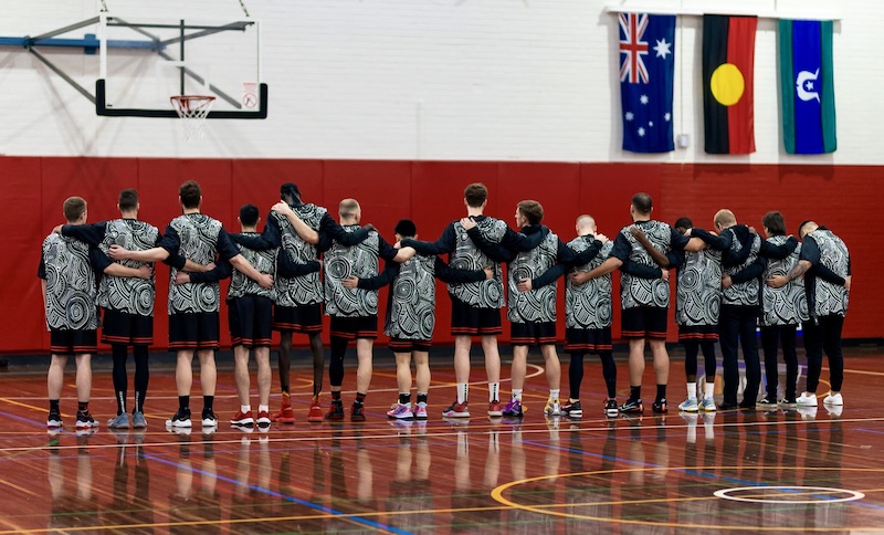 Students at a basketball game wearing in indigenous jersey.