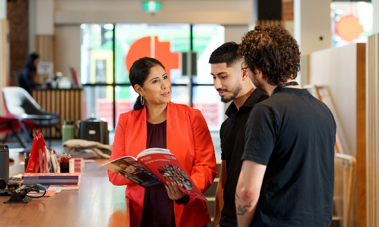 A parent and their child exploring university options with the help of an RMIT staff member