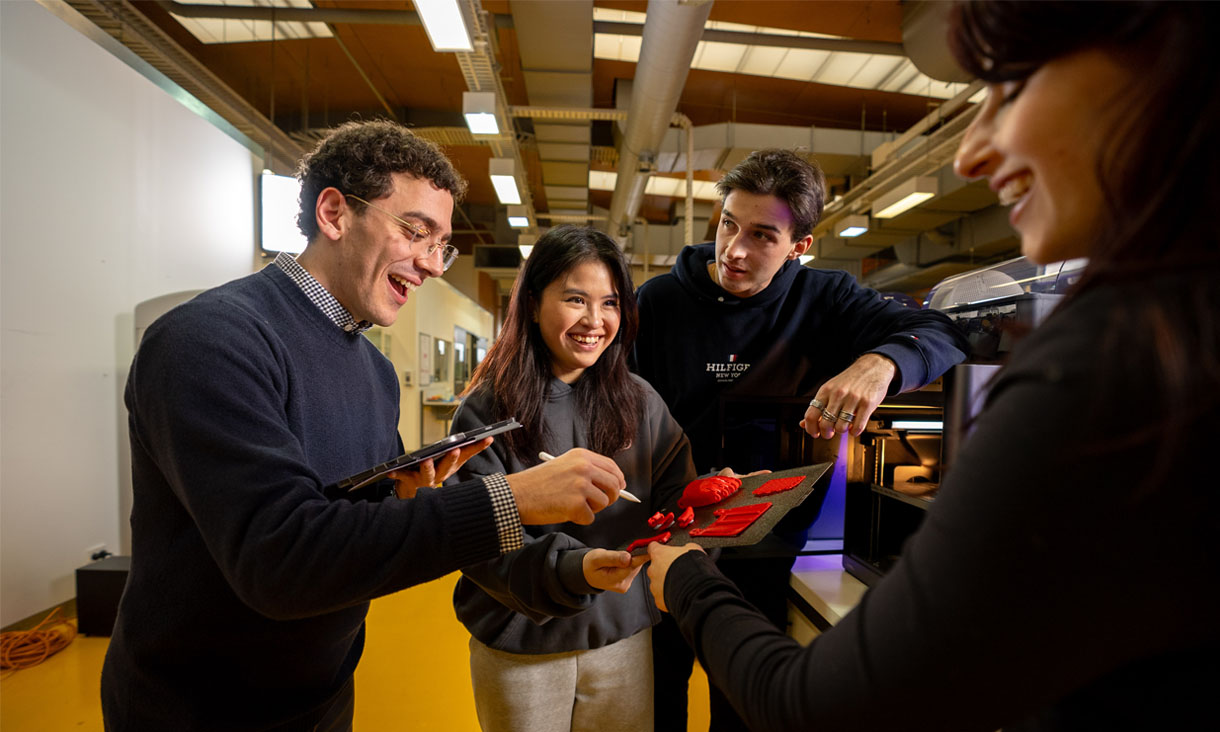 RMIT staff and students looking at 3D printed items in a workshop
