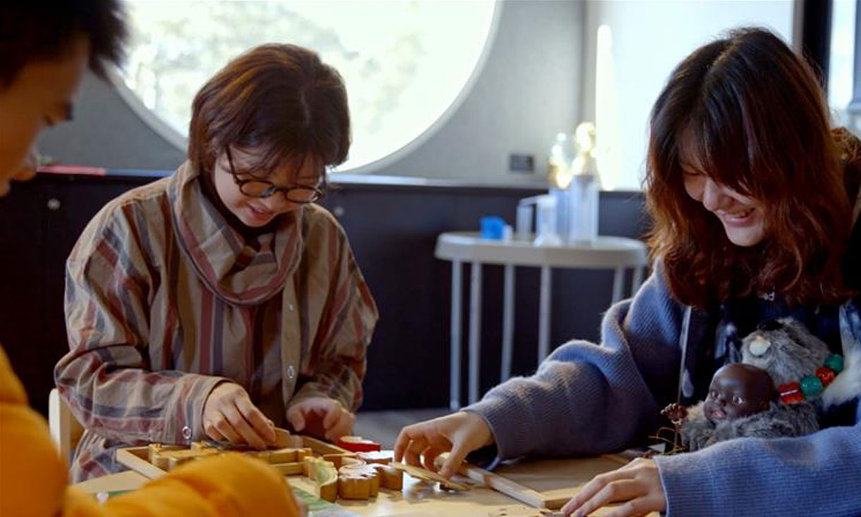 3 students sitting working on craft projects at an early childhood learning centre