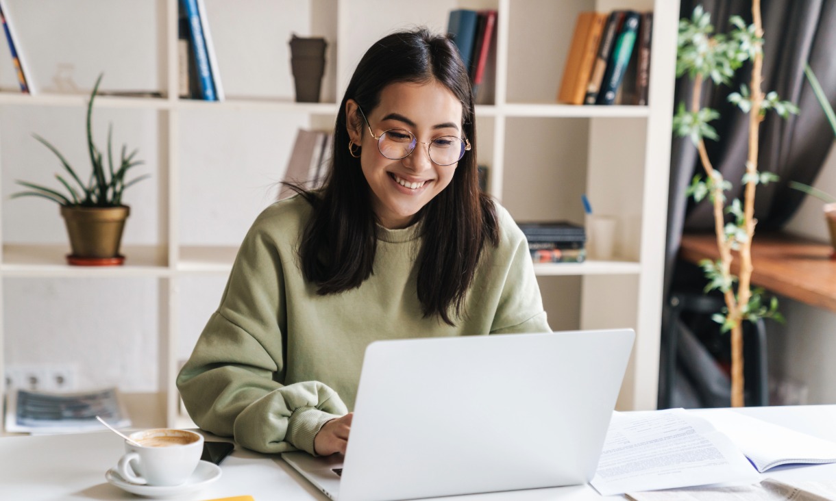 Woman looking down at laptop smiling. 