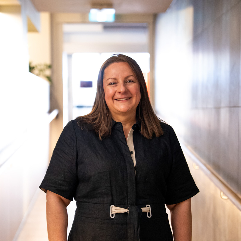 A portrait photograph of Kate smiling and looking directly at the camera.