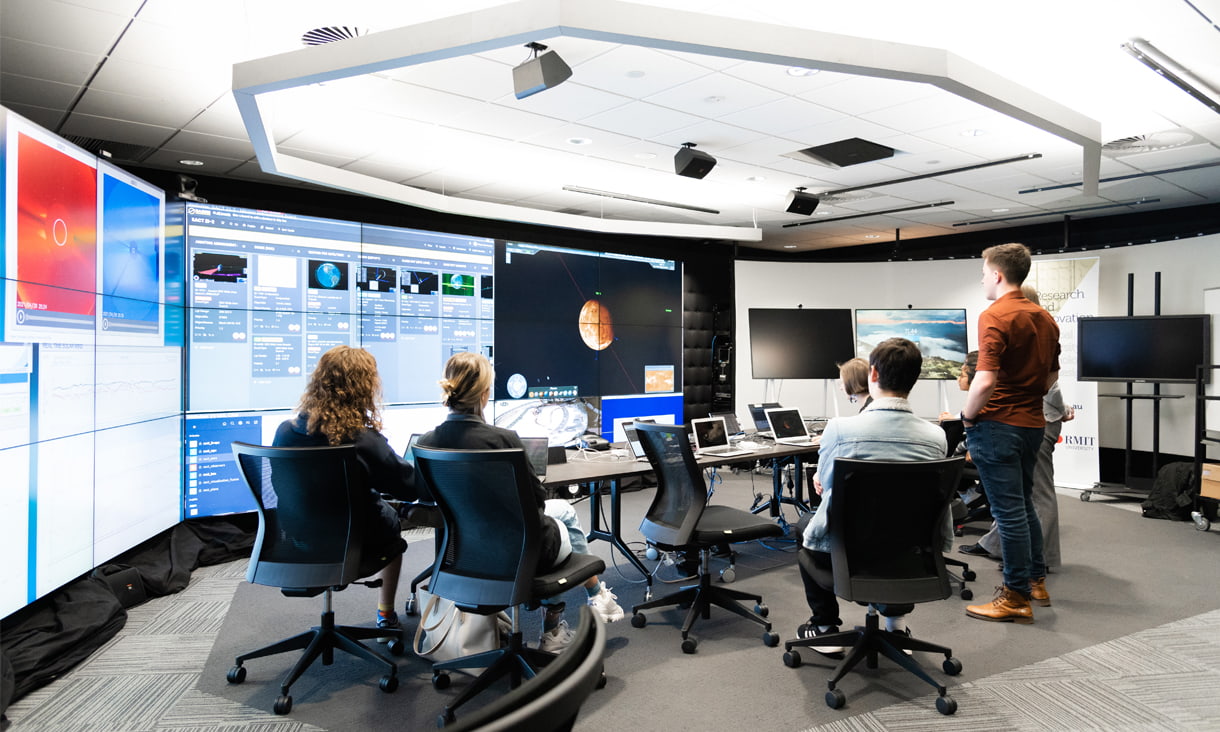 Students standing and sitting in a space lab facility