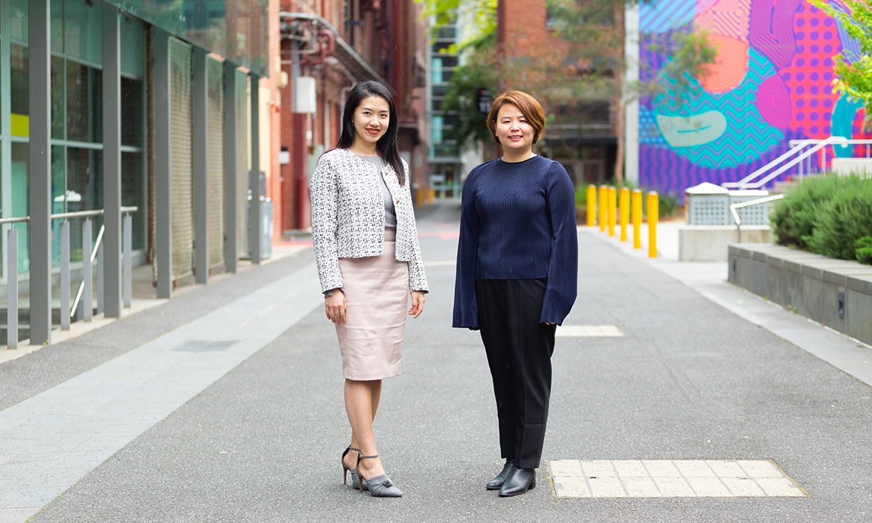 RMIT Chinese alumni Christie Ding and Hazel Hu walking down Bowen Street