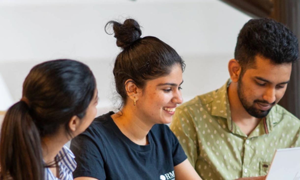 Three students sitting at laptop