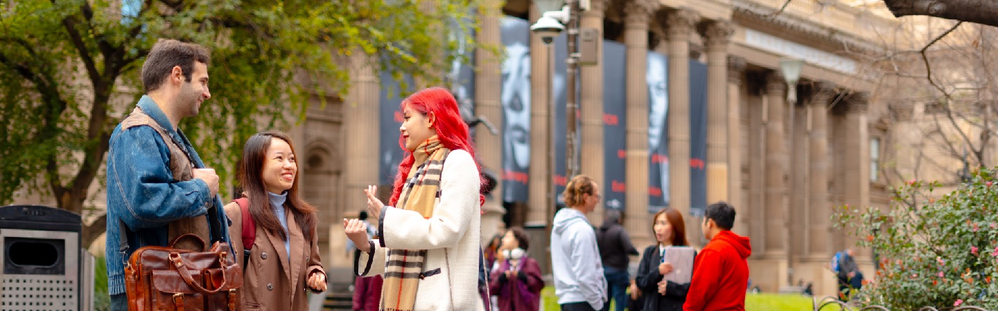 Postgraduate RMIT students standing in front of the State Victoria Library