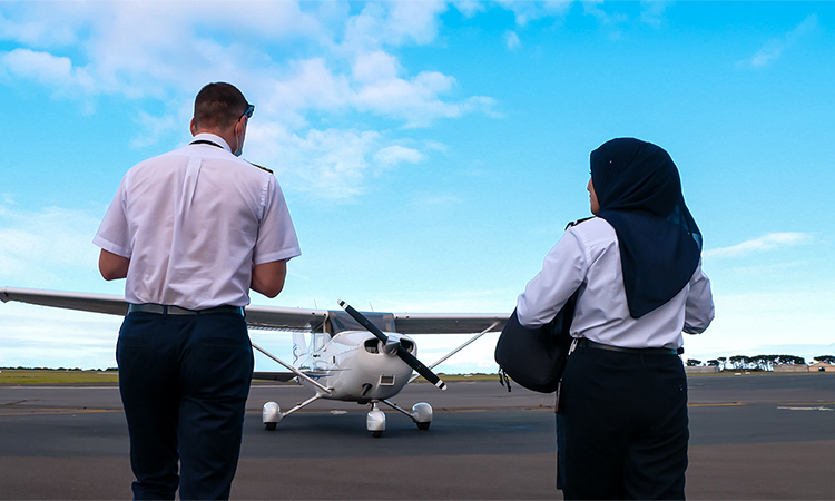 two flight training students facing plane