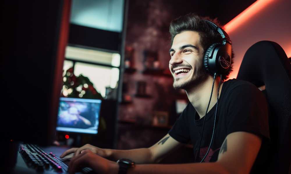 Person smiling with headphones in front of computer