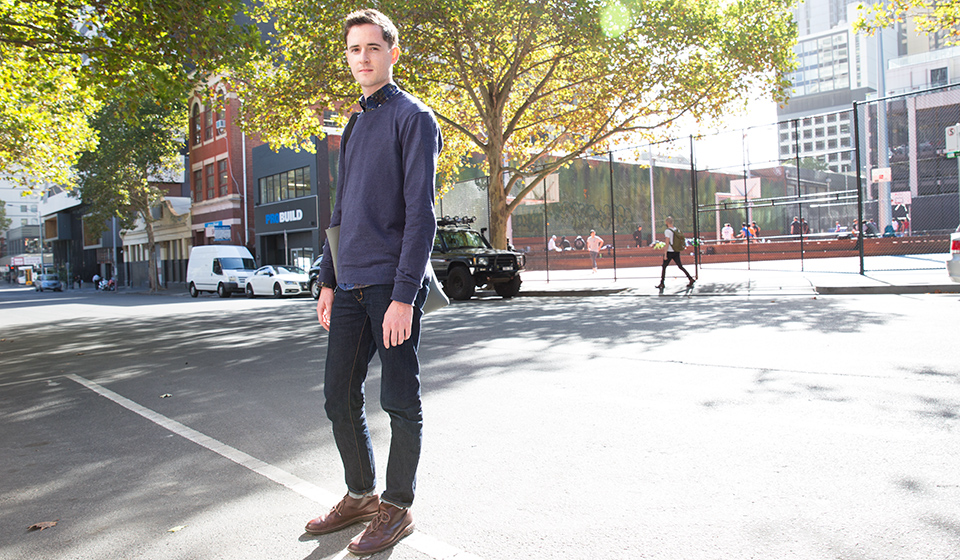 Male student standing in hte middle of the road, outside a Melbourne CBD space