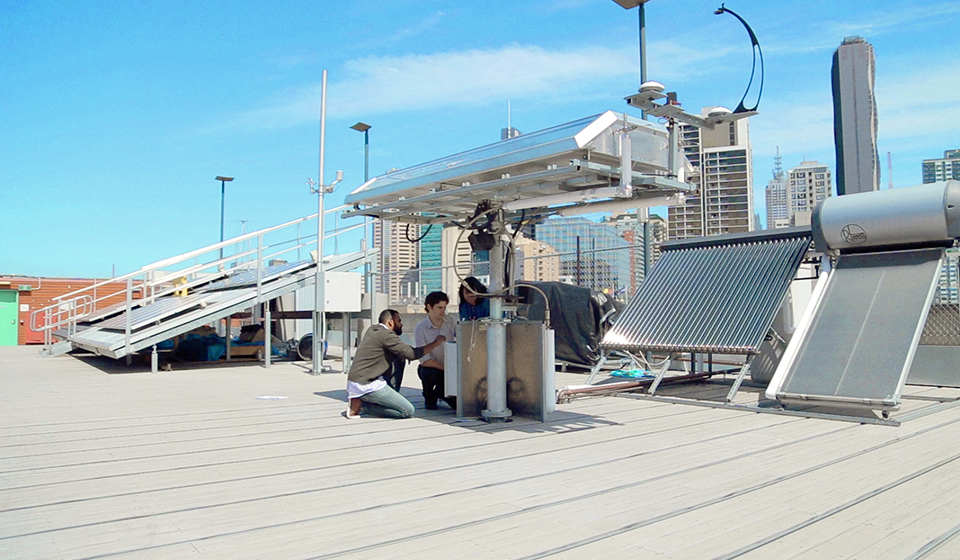 Engineering students working on a CBD rooftop building, surrounded by solar panels