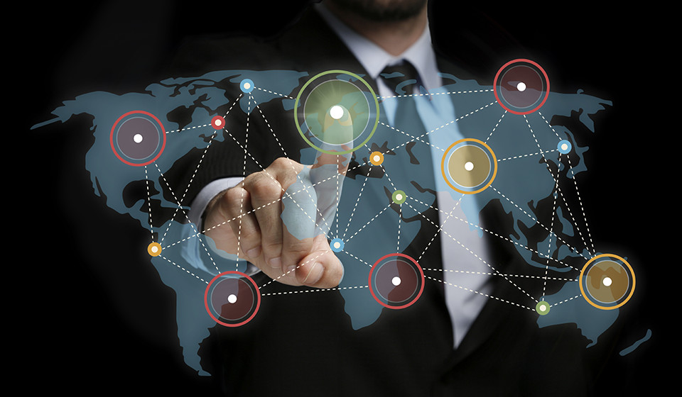 Torso of a business person pointing at an abstract image of a world map with network points