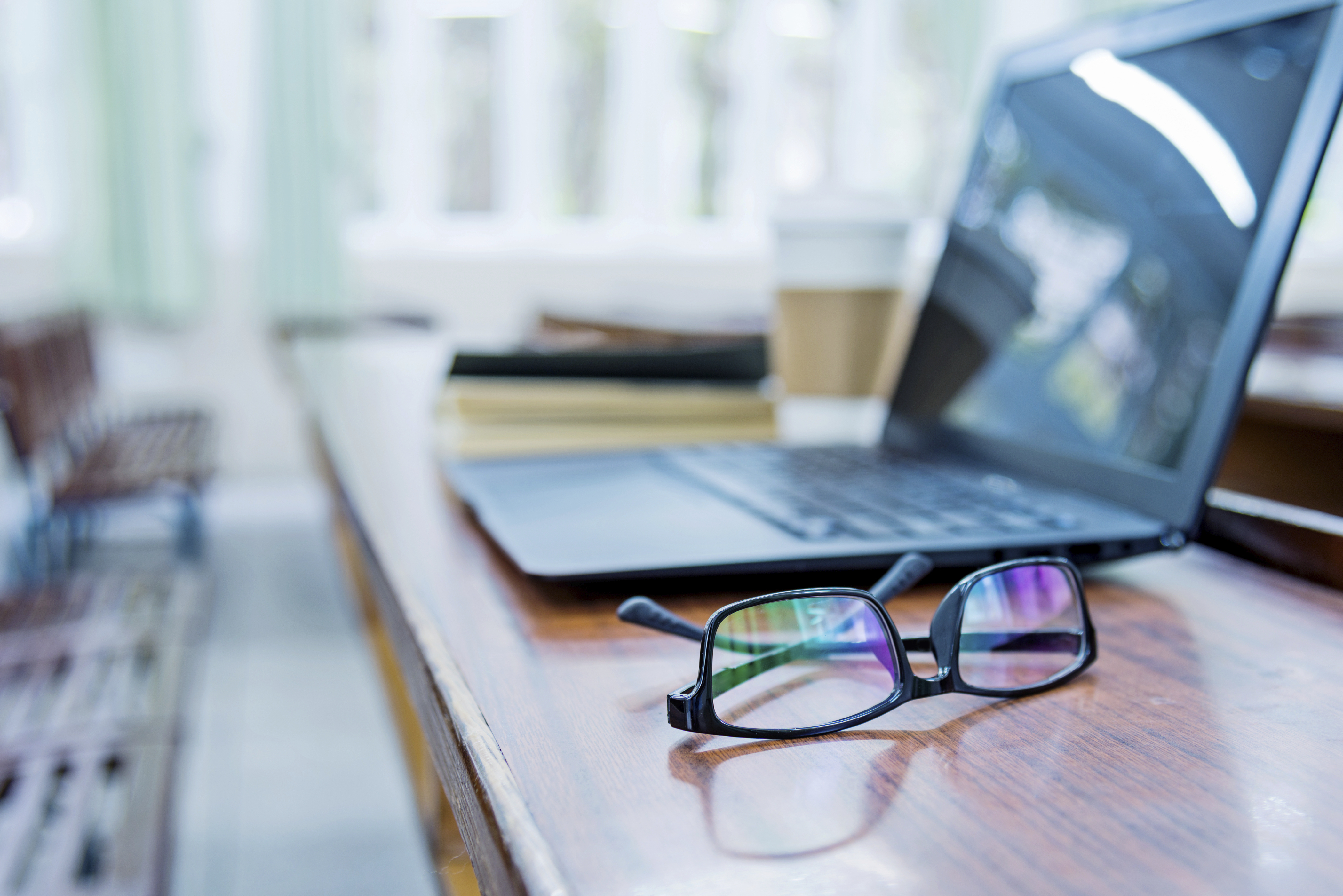 Glasses and laptop on a desk