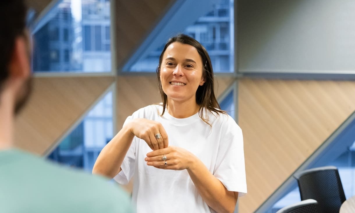 Female student miming a hand-gesture inside a classroom