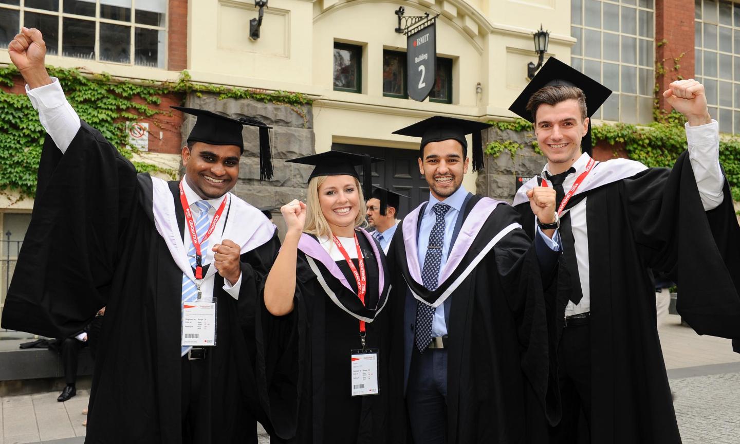 Happy students wearing academic gowns