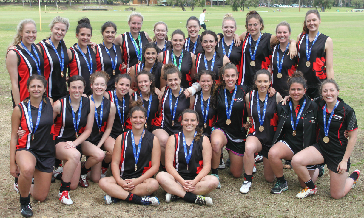 Group shot of Women's AFL team celebrating with gold medals around their necks	