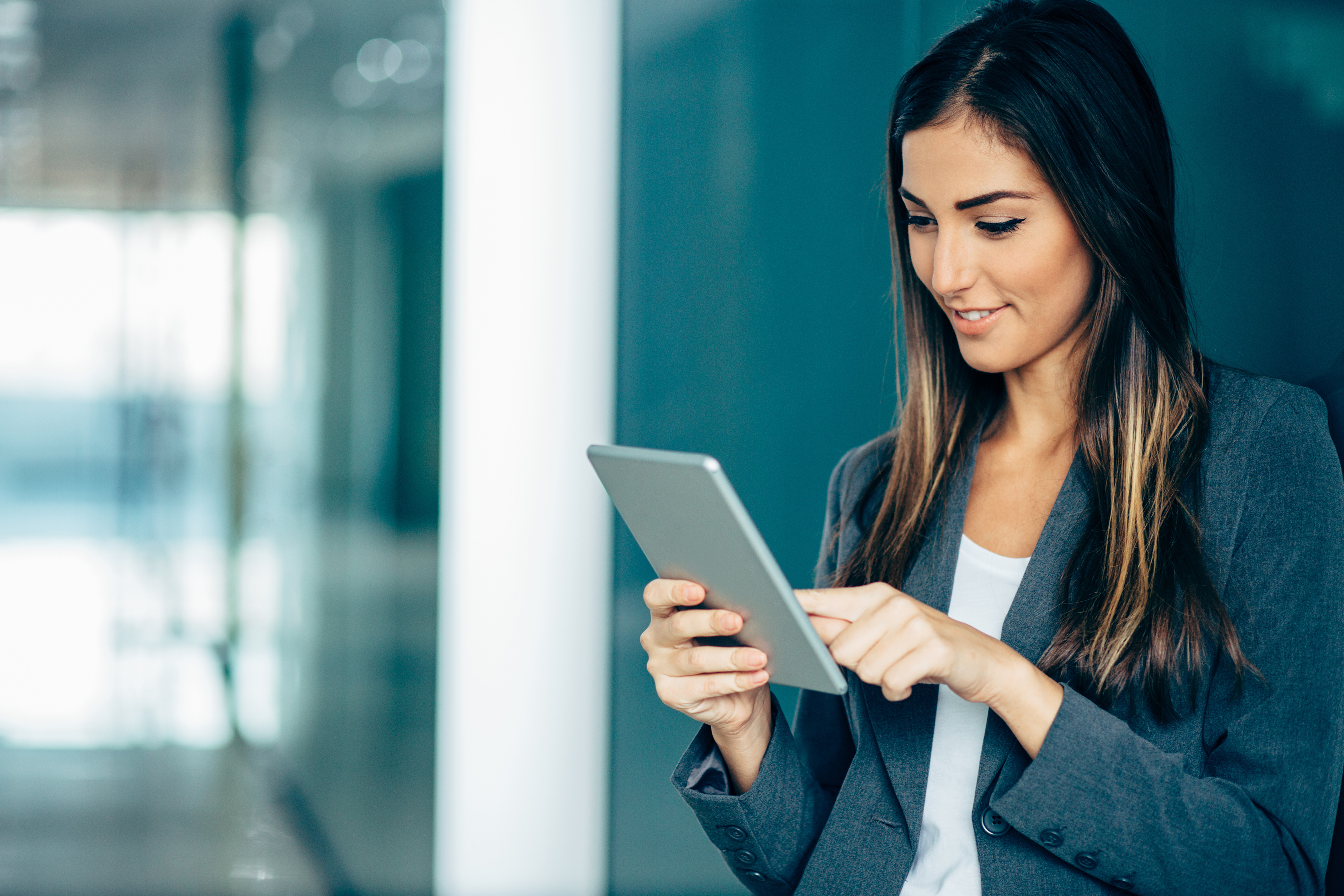 A female banker holding and interacting with a tablet device in her hands
