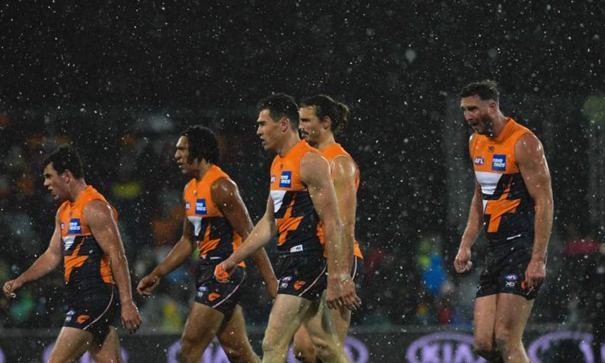 Jeremy Cameron of the Giants (centre) and team mates are seen as it snows during the Round 21 AFL match between the GWS Giants and the Hawthorn Hawks Manuka Oval in Canberra, Friday, August 9, 2019. Photo: Lukas Coch, AAP.