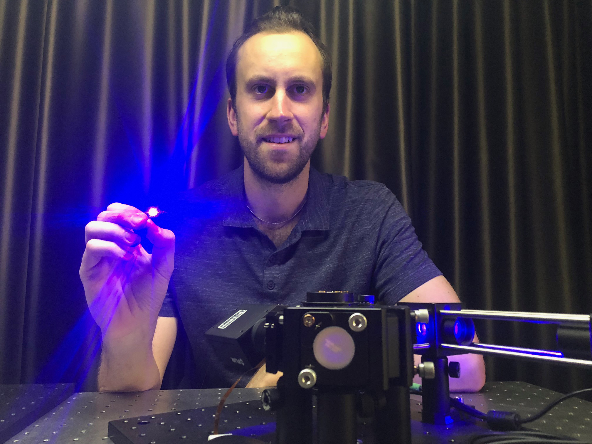 Dr Antony Orth holding an ultra-thin microendoscope used in the study.