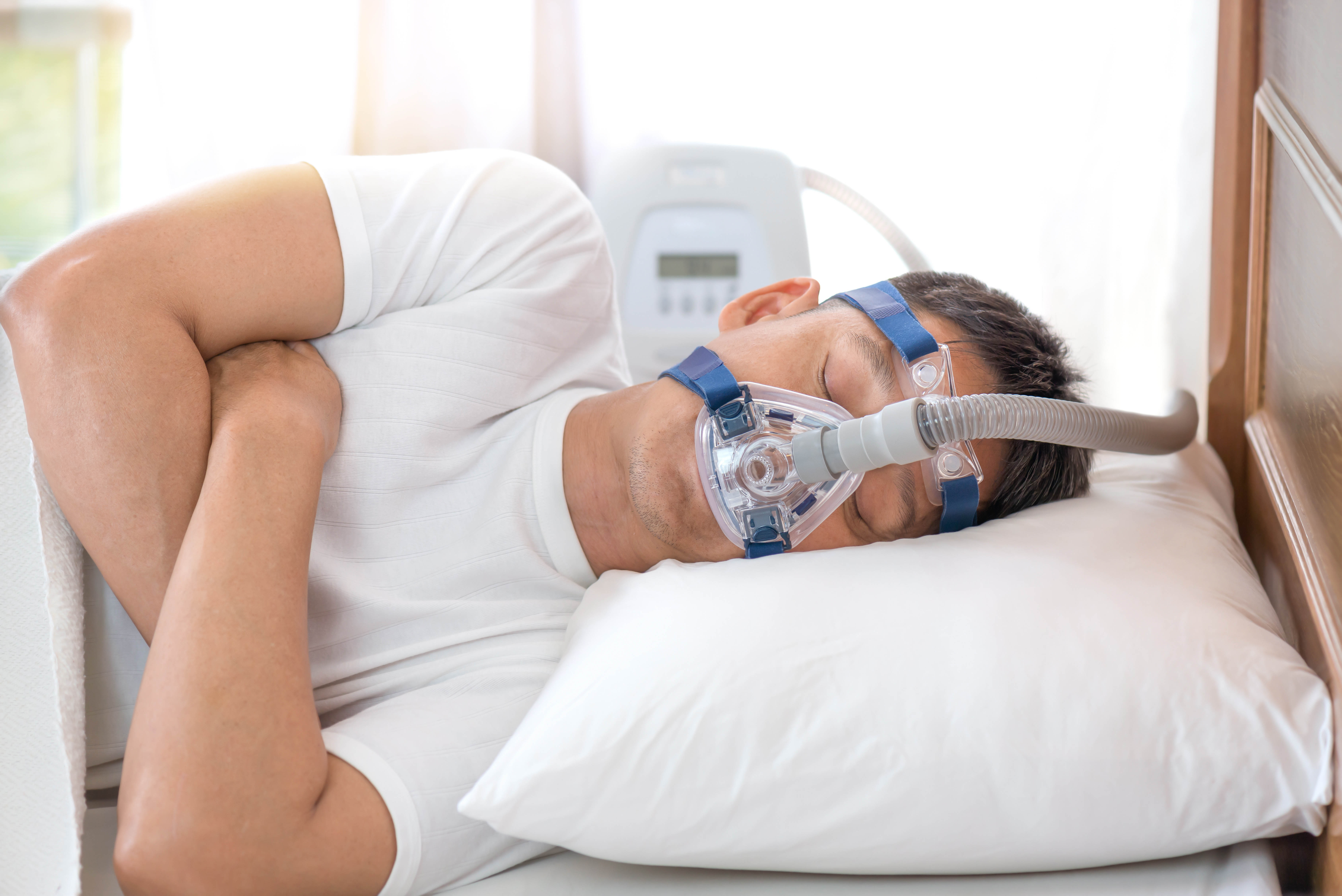 man sleeping with CPAP machine on