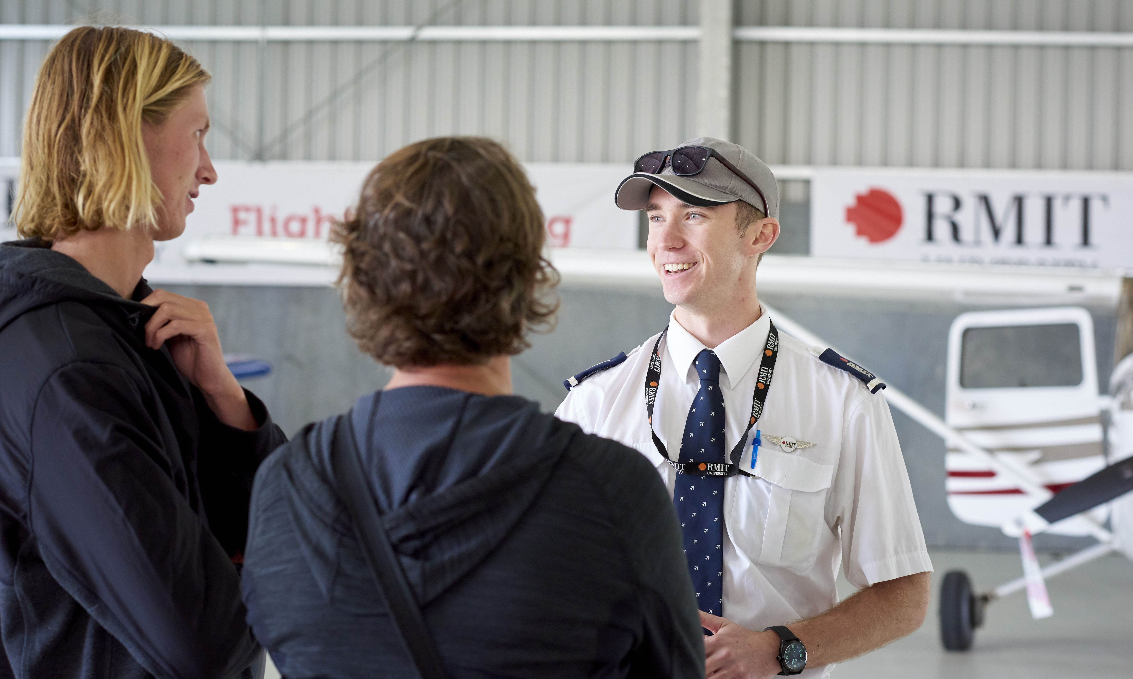 An RMIT pilot talks to two protective students at the Bendigo Flight Training School.