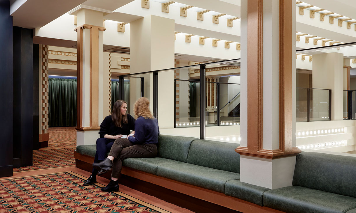Two women sit in The Capitol Theatre lobby