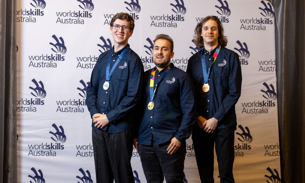 Additive Manufacturing winners lined up in front of WorldSkills backdrop