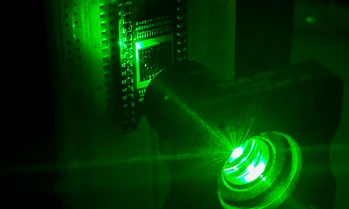 The neuromorphic vision chip (left) in a demonstration (in visible light) of the team's experiment, which used ultraviolet light. Credit: RMIT University