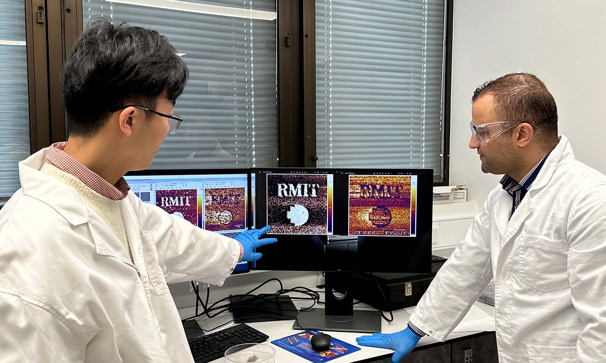 PhD scholar Xiangyang Guo shows the memory of the RMIT logo that the team’s device made and stored to Dr Ali Zavabeti. Credit: Seamus Daniel, RMIT University