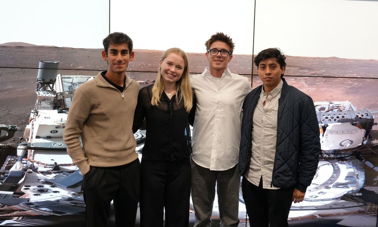Four students posing for camera in VX Lab.