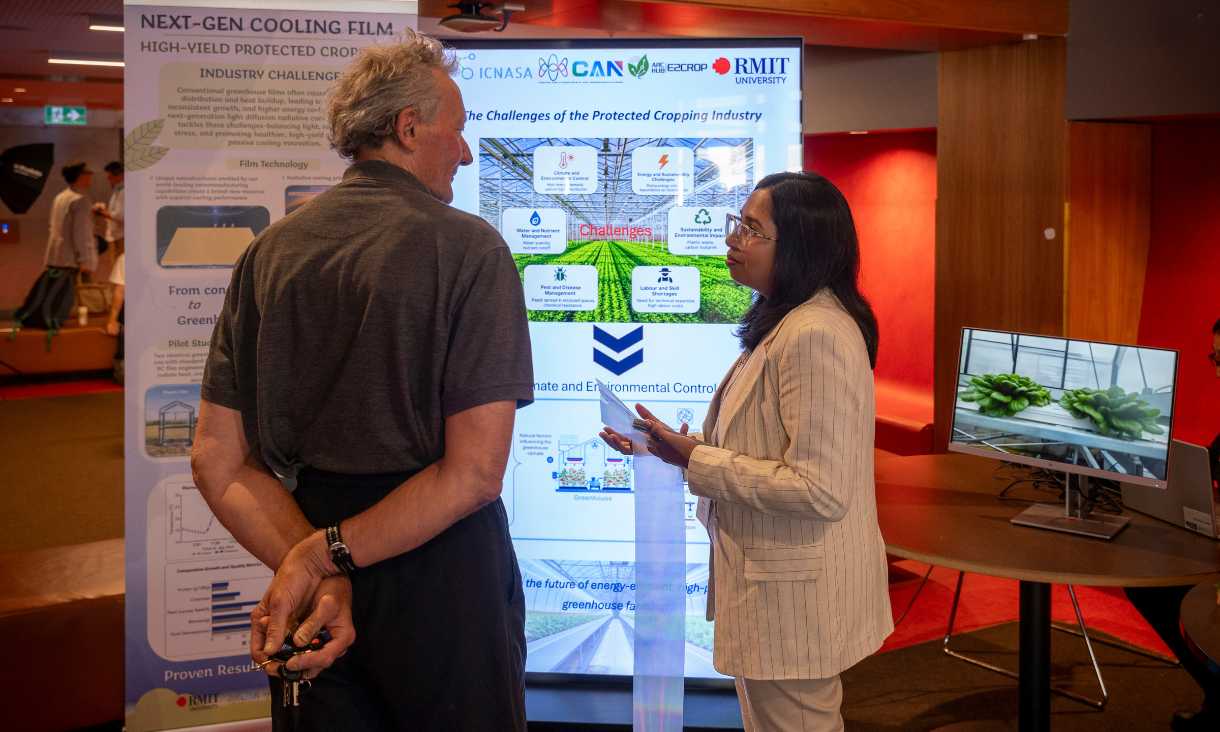 Two people engaged in conversation in front of banner promoting hub