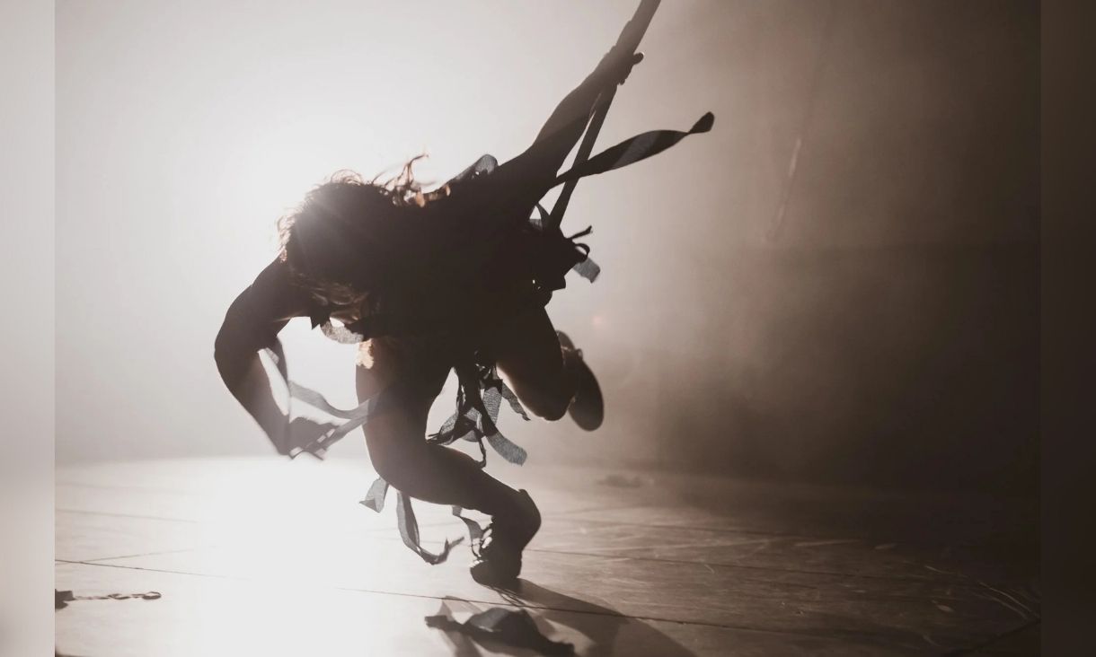 ‘Hot & Heavy’ (2025), Ironing Maidens. A contrasting light image of somebody dancing, looks like a shadow with tendrils of fabric hanging off them.