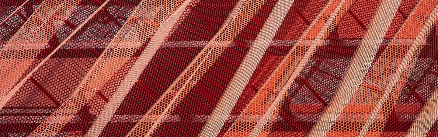 photo of exterior of building showing red metal mesh texturing